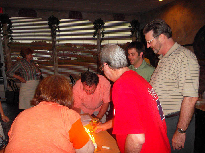 Mickey Kelley 60th B-Day - Mick Dan Kathy lighting cake